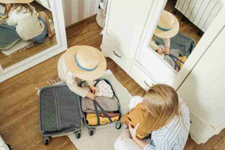 Une femme et un enfant qui boucle une valise